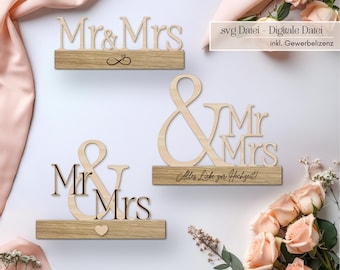May include: Three wooden Mr. & Mrs. signs with a light wood finish. The signs are on rectangular bases, with one featuring an infinity symbol, another with a heart, and the third with the text "Alles Liebe zur Hochzeit!"