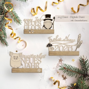 Puede incluir: Decoraciones de madera de Año Nuevo con texto en alemán. Los diseños incluyen un gnomo, un cerdo y fuegos artificiales con el año 2026. Las decoraciones están sobre una base de madera. La imagen incluye adornos festivos.