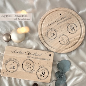Könnte beinhalten: Zwei Holzservierbretter mit eingravierten Designs. Eines ist rechteckig, das andere rund. Beide zeigen den Text "Liebes Christkind" und Illustrationen einer Kerze, eines Lebkuchenmanns und eines Milchkartons. Die Bretter sind hellbraun.