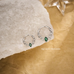 May include: Two silver hoop earrings with a vine design and a green gemstone. The earrings are shown in two sizes. The text on the image reads: 16g(1.2mm) / 8mm,10mm.