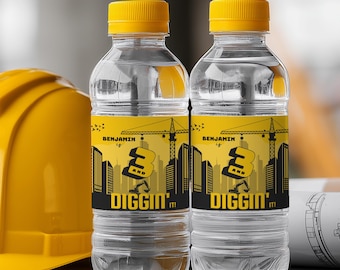May include: Two clear water bottles with yellow caps and labels. The labels feature a construction theme with a crane, cityscape, and the text "Benjamin is 3 and Diggin' It!" A yellow construction helmet is visible.