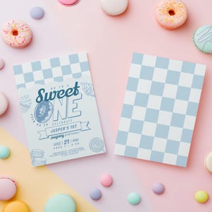 Könnte beinhalten: Zwei hellblau-weiß karierte Einladungen mit dem Text "Sweet One" und "Jasper's 1st sugary birthday" werden auf einem rosa Hintergrund angezeigt. Die Einladungen sind von Donuts, Macarons und bunten Süßigkeiten umgeben.