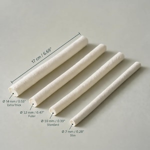 Può includere: Quattro aste cilindriche color bianco sporco lunghe 17 cm. I diametri sono etichettati come 14 mm per Extra Thick, 12 mm per Fuller, 10 mm per Standard e 7 mm per Slim, mostrando le quattro diverse opzioni di spessore disponibili.