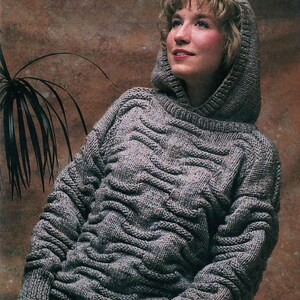 May include: A gray hooded sweater with a cable knit pattern. The sweater has a relaxed fit and a slouchy hood.