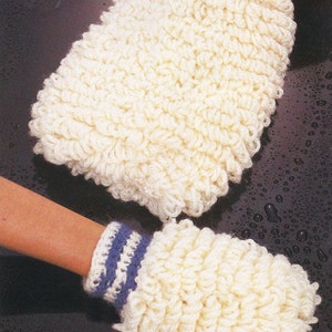 May include: A pair of white crocheted hand warmers with blue and white striped cuffs. The hand warmers are made with a textured, fluffy yarn.