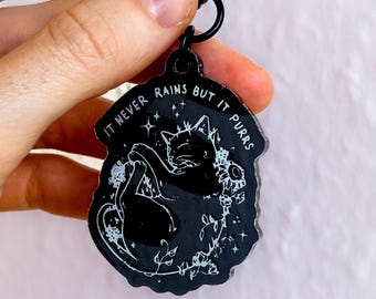 Llavero acrílico "Nunca llueve, pero ronronea" – Gato negro | Lindo llavero de gato | Regalo para amantes de los gatos y metaleros