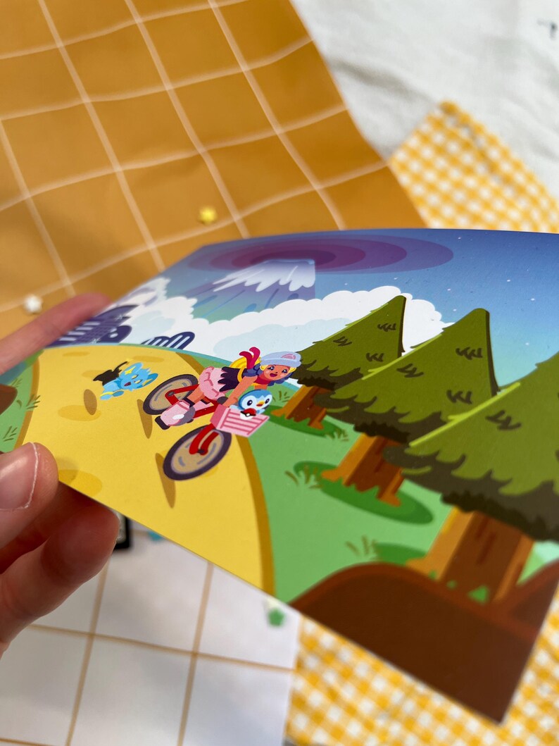 Może przedstawiać: Kolorowa ilustracja przedstawia postaci z kresk&oacute;wek jadące na rowerze przez krajobraz z drzewami i g&oacute;rą. Grafika charakteryzuje się jasnymi kolorami i kresk&oacute;wkowym stylem, skupiając się na postaciach i ich podr&oacute;ży.