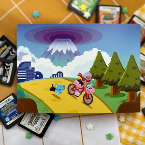 Może przedstawiać: Kolorowa ilustracja przedstawia osobę jadącą na r&oacute;żowym rowerze z koszykiem, w towarzystwie postaci z kresk&oacute;wek. W tle g&oacute;ra, drzewa i krajobraz miejski. Obraz otaczają liczne kartridże do gier Pokemon DS.