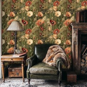 May include: A green floral wallpaper with a repeating pattern of red and orange poppies. The wallpaper is shown in a room with a leather armchair and a wooden side table.