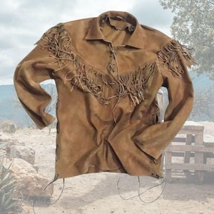 May include: A brown suede jacket with long sleeves and fringe detailing across the chest and shoulders. The jacket has a collared neckline and a lace-up closure. The jacket is a medium brown colour.