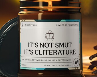 Może przedstawiać: Szklany słoik z brązowego szkła z białą etykietą, na której widnieje napis "It's not smut, it's cliterature." Etykieta zawiera również napis "100% natural soy wax blend w/ 100% cotton wick" oraz "Burn time - up to 50 hrs".