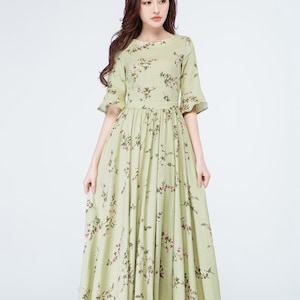 Peut inclure: Robe vert clair &agrave; imprim&eacute; floral. Col rond, manches courtes et taille cintr&eacute;e. La jupe longue est orn&eacute;e de motifs floraux roses. La robe mesure environ 150 cm de long.