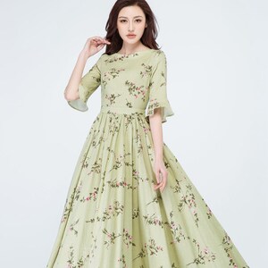 Peut inclure: Une robe vert clair &agrave; imprim&eacute; floral, avec un col rond et des manches courtes &eacute;vas&eacute;es. La robe pr&eacute;sente un corsage ajust&eacute; et une jupe longue et fluide. Le motif floral comprend des fleurs roses et des feuilles vertes.