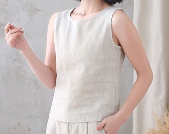 May include: A sleeveless linen top in a light beige color. The top has a scoop neckline and a relaxed fit.