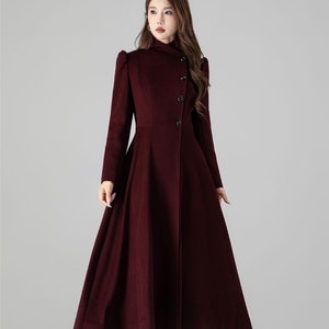May include: A long, burgundy coat with a high collar and a flared skirt. The coat has a button closure and long sleeves. The hemline reaches the ankles. The number "4511" is visible in the bottom right corner.