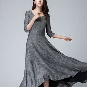 K&ouml;nnte beinhalten: Ein graues Leinen-Maxikleid mit einem hohen, niedrigen Saum. Das Kleid hat einen runden Ausschnitt und 3/4 &Auml;rmel.