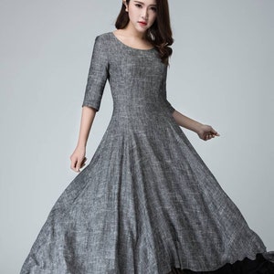 K&ouml;nnte beinhalten: Ein graues Leinenkleid mit einem schwarzen T&uuml;llunterrock. Das Kleid hat einen runden Ausschnitt und 3/4 &Auml;rmel. Das Model tr&auml;gt schwarze Abs&auml;tze.