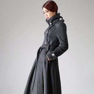 May include: A long, gray, double-breasted coat with a high collar and a belt. The coat has silver buttons and a flared skirt.