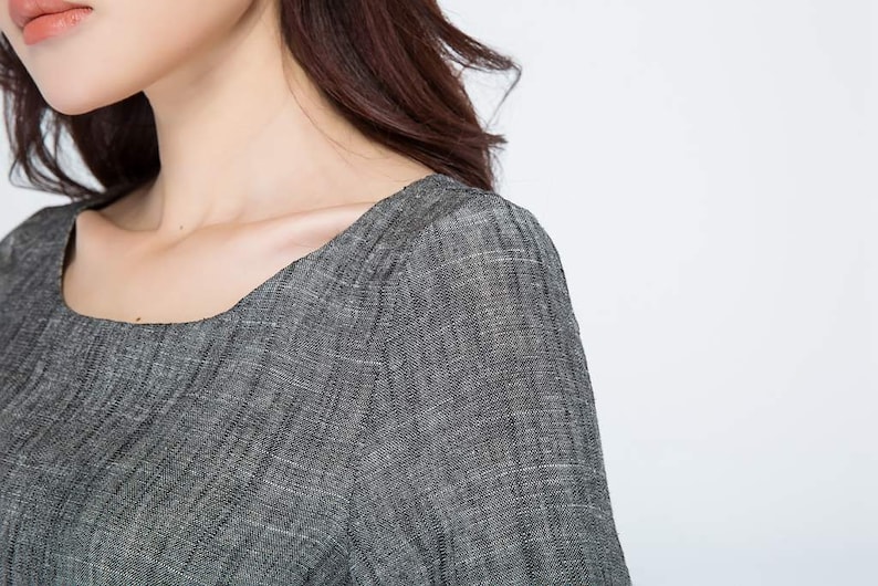 May include: Close-up of a gray linen dress with a square neckline and short sleeves.