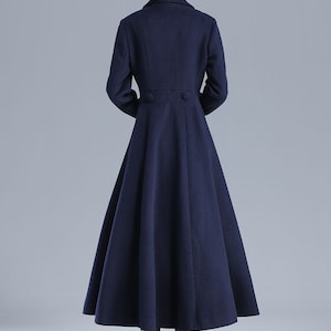 May include: A long, navy blue coat with a flared skirt and a double-breasted closure. The coat has a classic, elegant style.