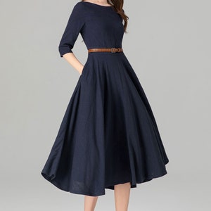 May include: A navy blue midi dress with a brown belt and a slightly flared skirt.