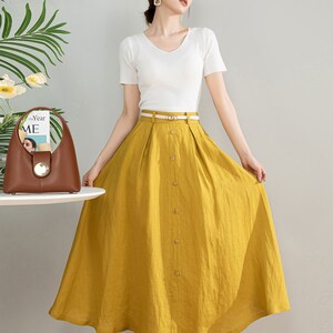 May include: A yellow linen skirt with a button front and a belt. The skirt is midi length and has a flowy silhouette.