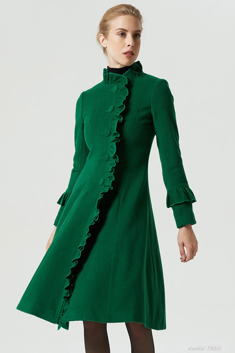 May include: A green wool coat with a ruffled collar and cuffs. The coat has a fitted bodice and a flared skirt.