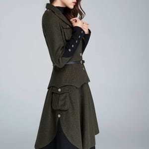 Puede incluir: Una chaqueta de lana verde con ribetes negros en las mangas y una falda a juego. La chaqueta tiene un cintur&oacute;n y un bolsillo grande en la falda.