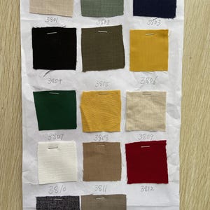 May include: A swatch card with 14 different fabric samples. The samples are arranged in four rows of three, with one sample at the bottom. The samples are numbered 3801 through 3814. The fabric samples are in a variety of colors and textures, including beige, green, blue, black, yellow, red, white, and gray.