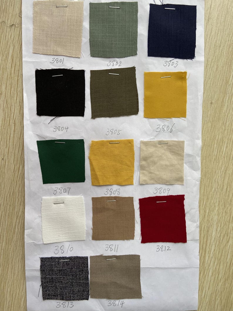 May include: A swatch card with 14 different fabric samples. The samples are arranged in four rows of three, with one sample at the bottom. The samples are numbered 3801 through 3814. The fabric samples are in a variety of colors and textures, including beige, green, blue, black, yellow, red, white, and gray.