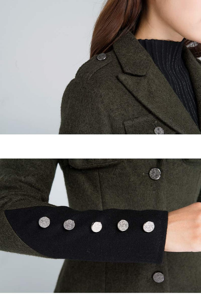 Puede incluir: Un abrigo de lana verde oscuro con ribetes negros en las mangas. El abrigo tiene botones plateados y un cuello.
