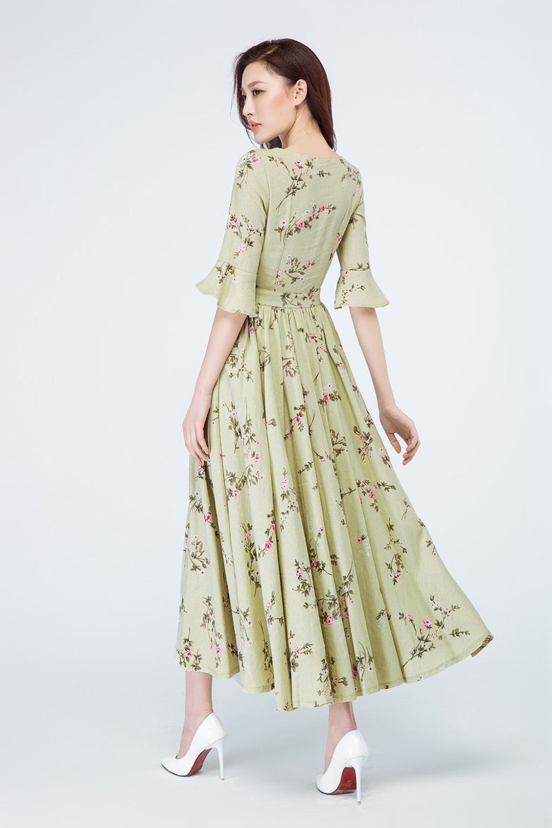 Peut inclure: Robe &agrave; imprim&eacute; floral vert clair avec un d&eacute;collet&eacute; en V et des manches &eacute;vas&eacute;es. La robe pr&eacute;sente une taille cintr&eacute;e et une jupe fluide. Le mod&egrave;le porte des talons hauts blancs. La robe est de longueur midi.