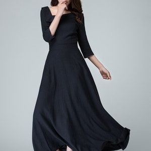 May include: A black maxi dress with a square neckline and three-quarter sleeves. The dress has a flowing skirt and is made of a lightweight fabric.