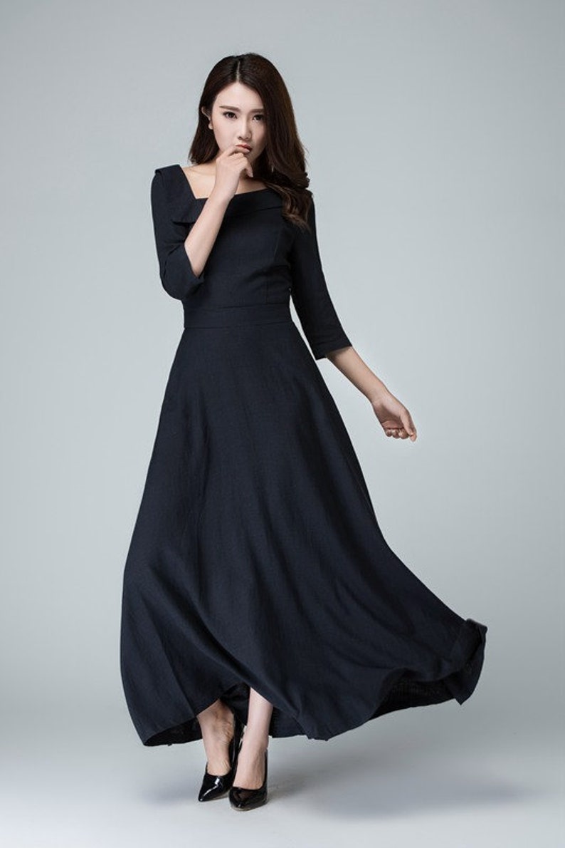 May include: A black maxi dress with a square neckline and three-quarter sleeves. The dress has a flowing skirt and is made of a lightweight fabric.