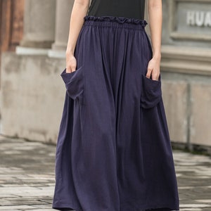 May include: Navy blue wide-leg pants with large front pockets and a ruffled waistband. The pants are made of a flowing fabric and are paired with a black top. The text "4-navy blue" is visible at the bottom of the image.