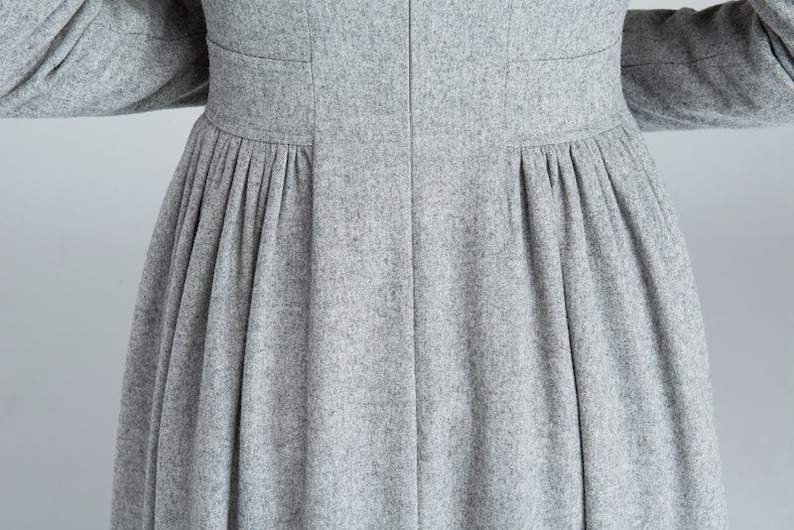 May include: A gray wool dress with a pleated skirt and a fitted bodice.
