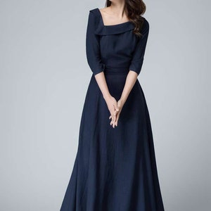 May include: A navy blue maxi dress with a square neckline and three-quarter sleeves. The dress has a fitted bodice and a flowing skirt.