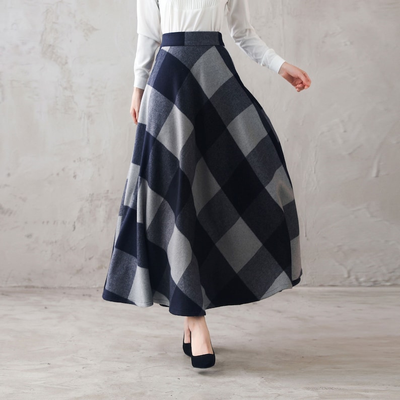 May include: A long, gray and navy plaid skirt with a high waist and a flowing silhouette.