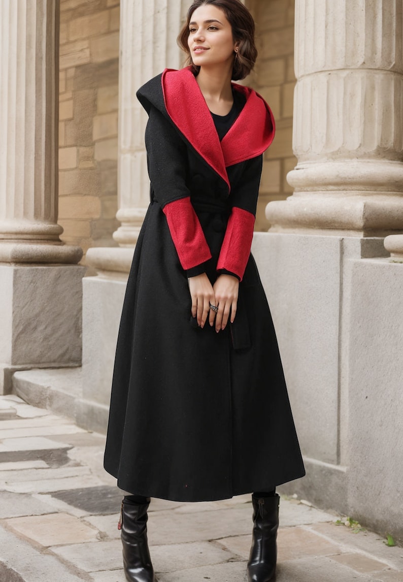 May include: A black hooded coat with red trim on the hood and sleeves. The coat has a tie belt and a long, flowing skirt.