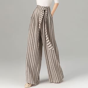 May include: Wide-leg pants with a striped pattern in beige and black. The pants have a self-tie belt at the waist.