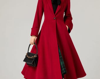 May include: A red long-sleeved coat with a single button closure and a flared skirt. The coat has a black collar and a black bow tie. The model is wearing black tights and black heeled boots.