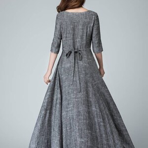 K&ouml;nnte beinhalten: Ein graues Leinen-Maxikleid mit einer Schleife in der Taille und einem schwarzen T&uuml;ll-Unterrock.