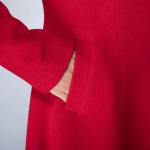 May include: A red wool coat with a single pocket on the left side.