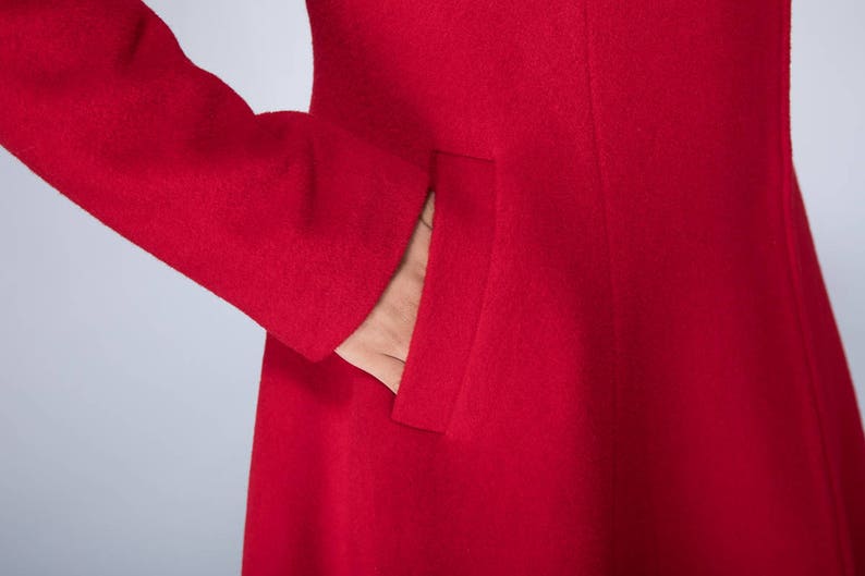 May include: A red wool coat with a single pocket on the left side.