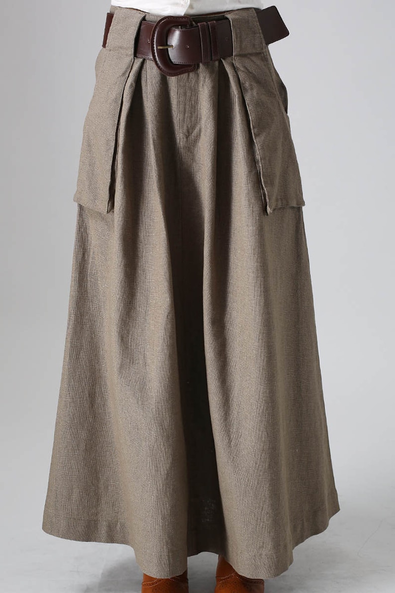 May include: A long, brown, linen skirt with a wide brown leather belt and large pockets on the sides.