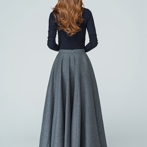 Op de afbeelding: Een grijze maxi-rok met een hoge taille en een volle, vloeiende silhouet. De rok is gemaakt van een zachte, comfortabele stof en heeft een ritssluiting aan de achterkant.