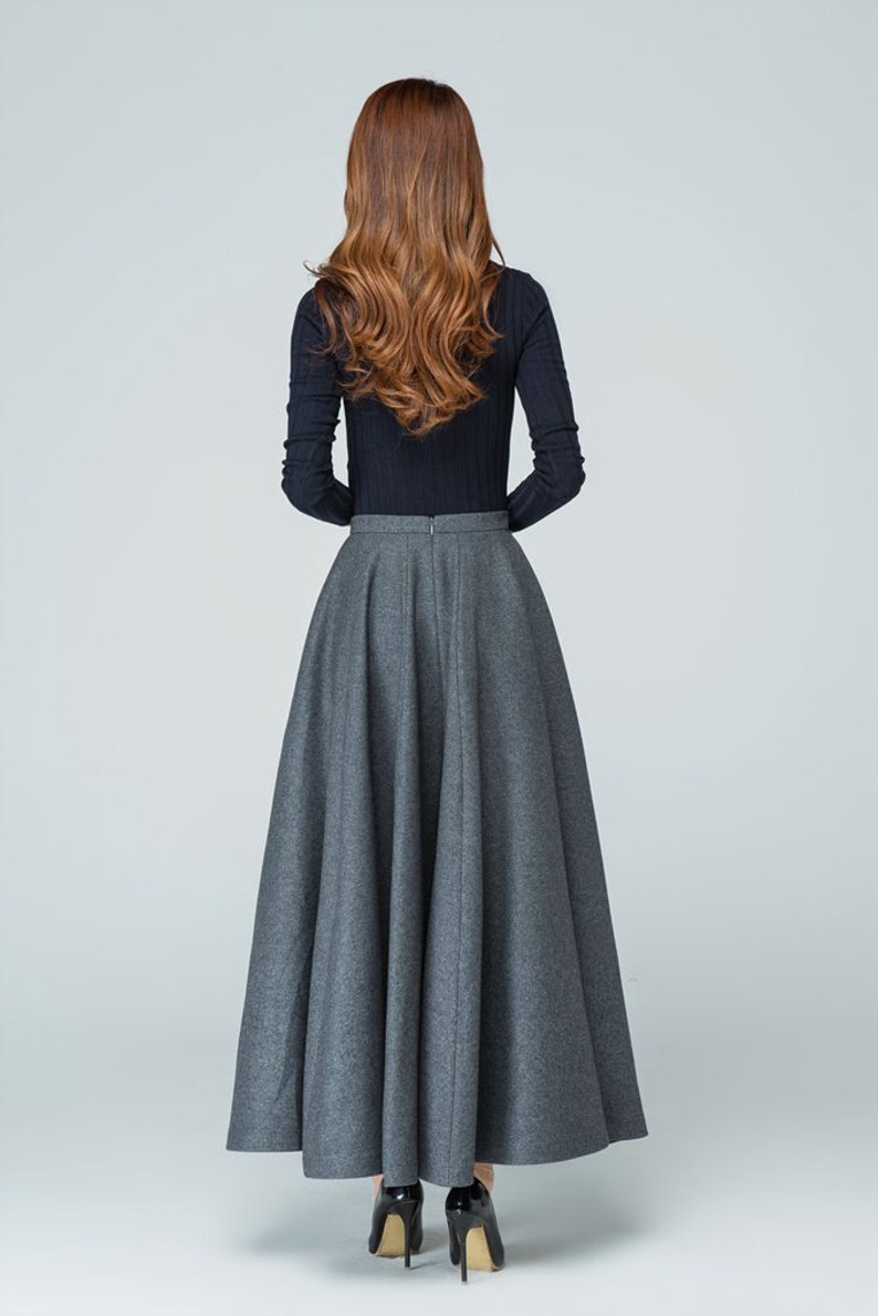 Op de afbeelding: Een grijze maxi-rok met een hoge taille en een volle, vloeiende silhouet. De rok is gemaakt van een zachte, comfortabele stof en heeft een ritssluiting aan de achterkant.