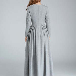 May include: A gray long-sleeved dress with a gathered skirt and a round neckline.