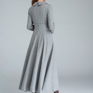 Puede incluir: Un vestido gris de manga larga con cuello de Peter Pan y falda acampanada. El vestido est&aacute; hecho de una tela suave y texturizada.