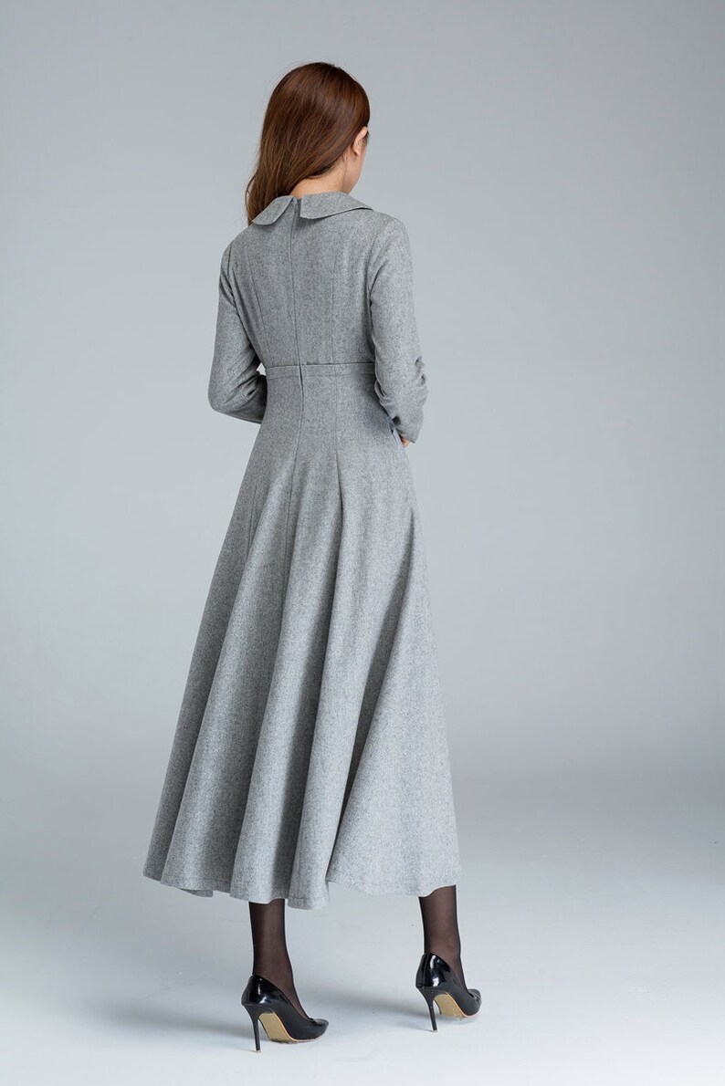 Puede incluir: Un vestido gris de manga larga con cuello de Peter Pan y falda acampanada. El vestido est&aacute; hecho de una tela suave y texturizada.